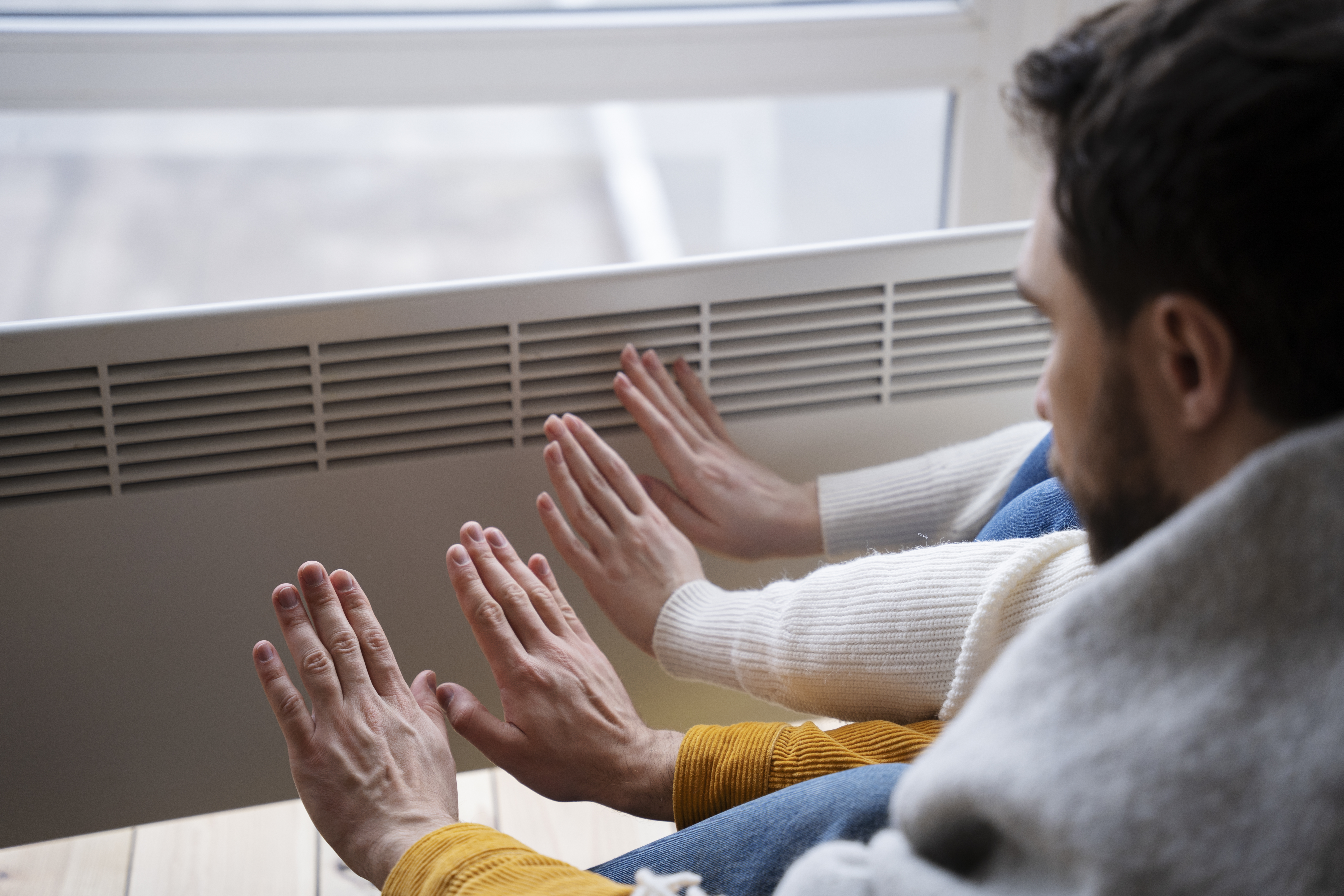 people-warming-up-their-hands-with-heater